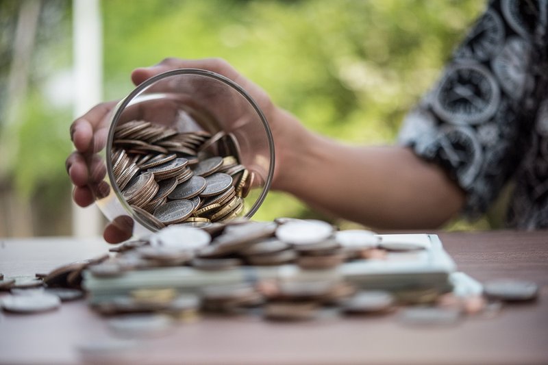 hand-putting-coins-in-jar-with-money-stack-step-g-2023-11-27-05-25-13-utc