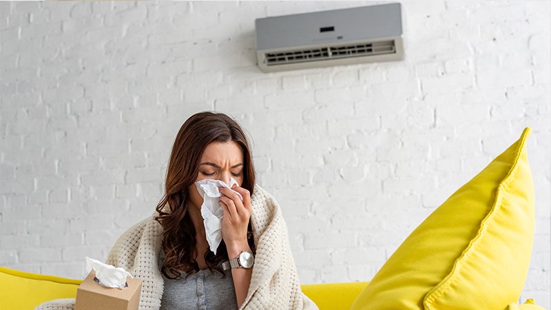 sick-woman-with-paper-napkin-warming-under-blanket-2023-11-27-05-34-31-utc